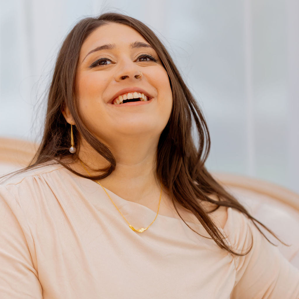 Woman wearing a beige top with a blurred background