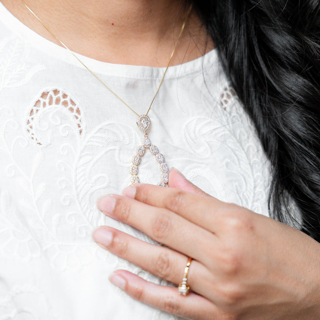 Person wearing a necklace and ring, with a focus on jewelry details.