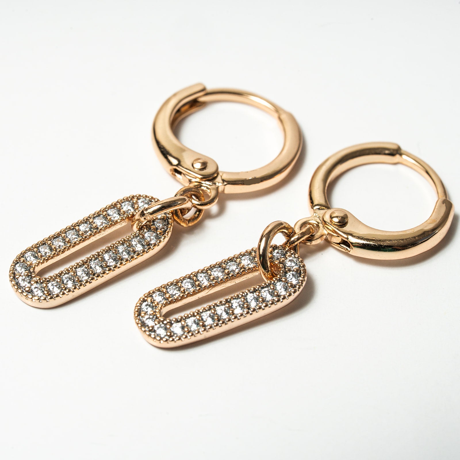 Rose gold hoop earrings with crystal embellishments on a white background