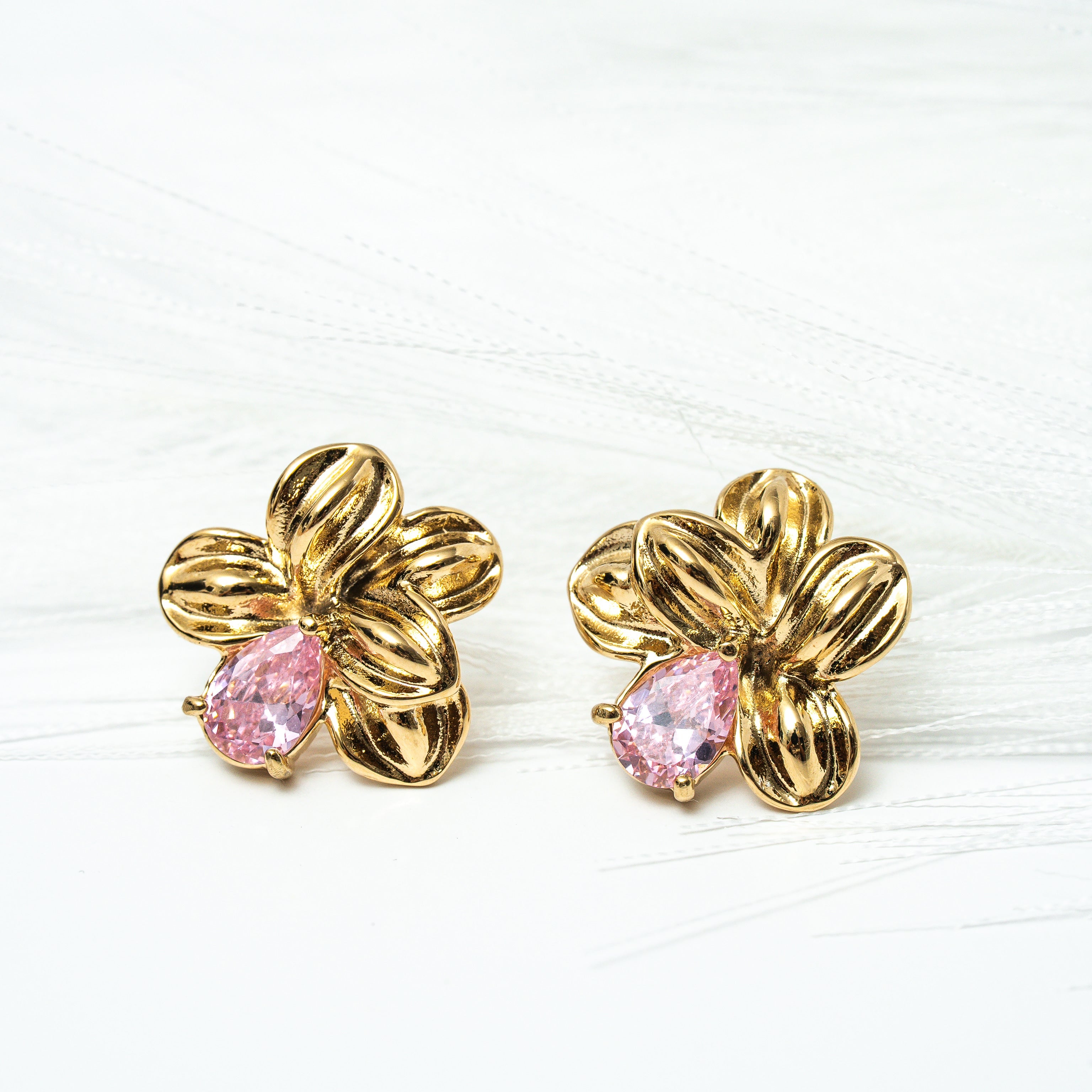 Gold flower-shaped earrings with pink centers on a white background. Harma gold plated Bloom Again Gold Earrings
