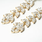 Gold and clear teardrop-shaped jewelry pieces on a white background. Chandelier Marquise Dangle Earrings Cubic Zirconia Fancy 
