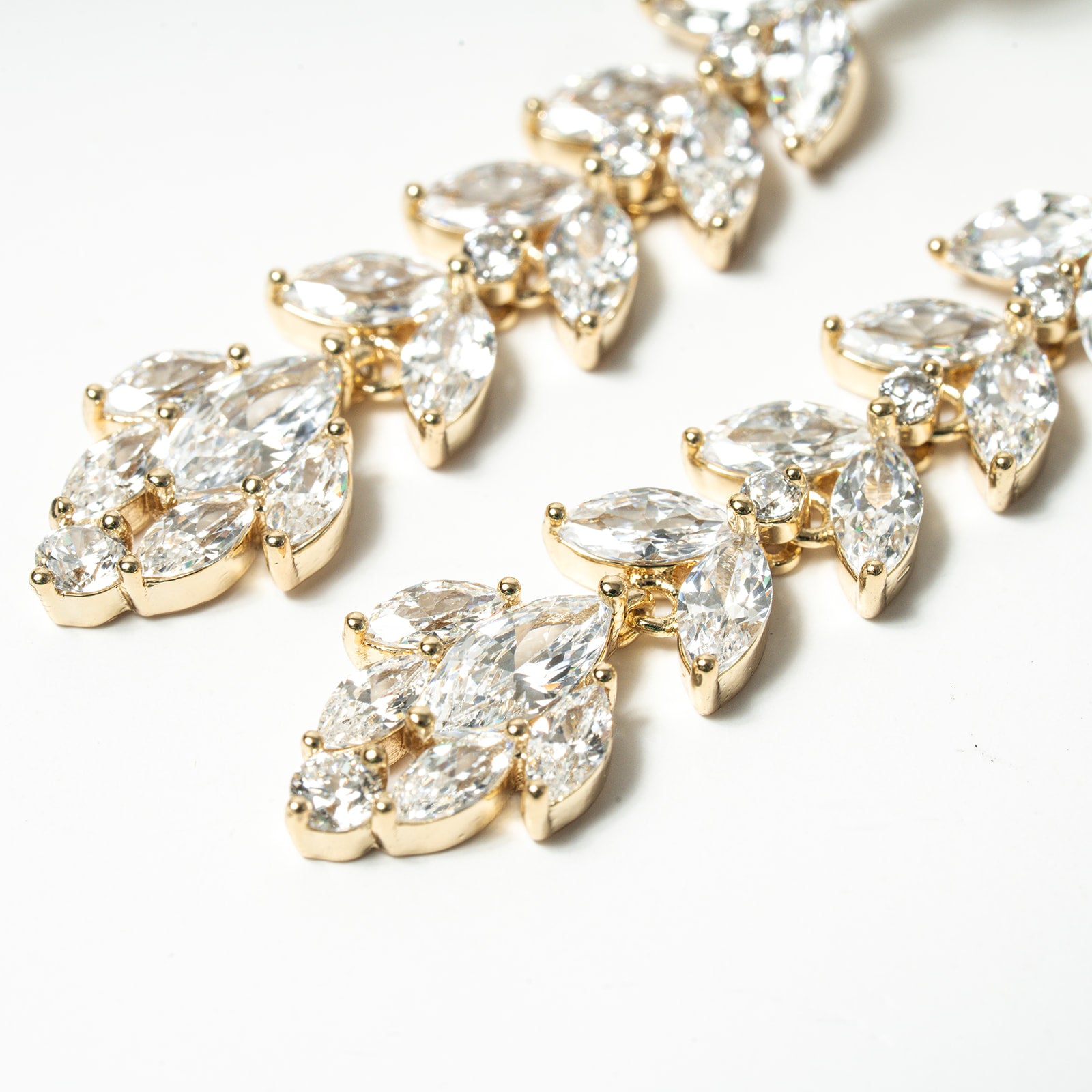 Gold and clear teardrop-shaped jewelry pieces on a white background. Chandelier Marquise Dangle Earrings Cubic Zirconia Fancy 