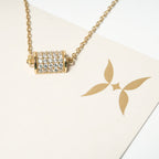 Gold necklace with a diamond pendant on a white card with a gold logo. Harma 14k gold plated Golden Barrel Chain Bracelet