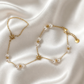 Gold necklace and bracelet set on a satin surface