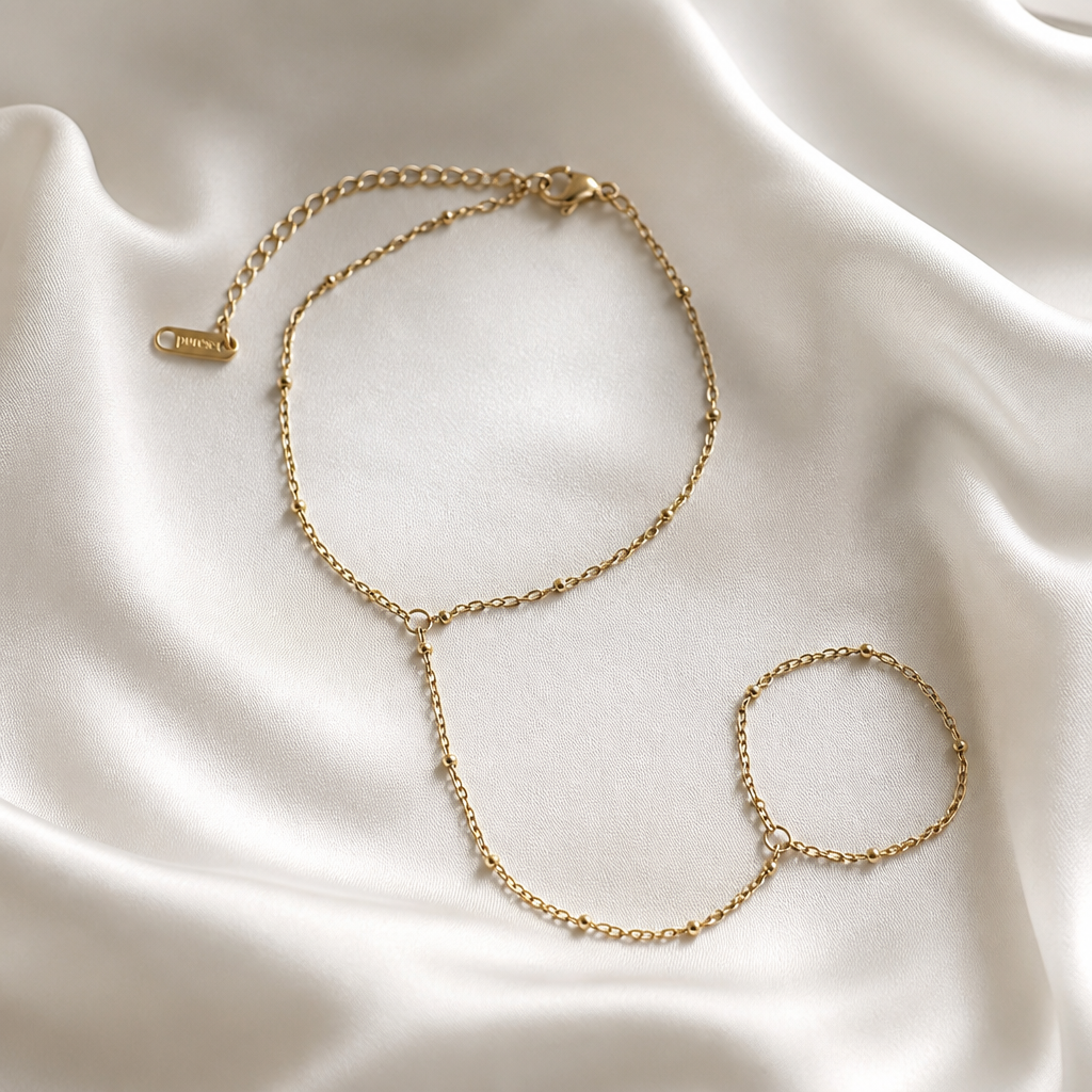 Gold chain bracelet on a white fabric background