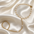 Gold chain necklace with pearls on a satin surface