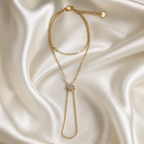 Gold necklace with a pendant on a satin background