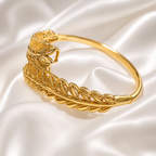Gold bracelet with leaf design on a satin background