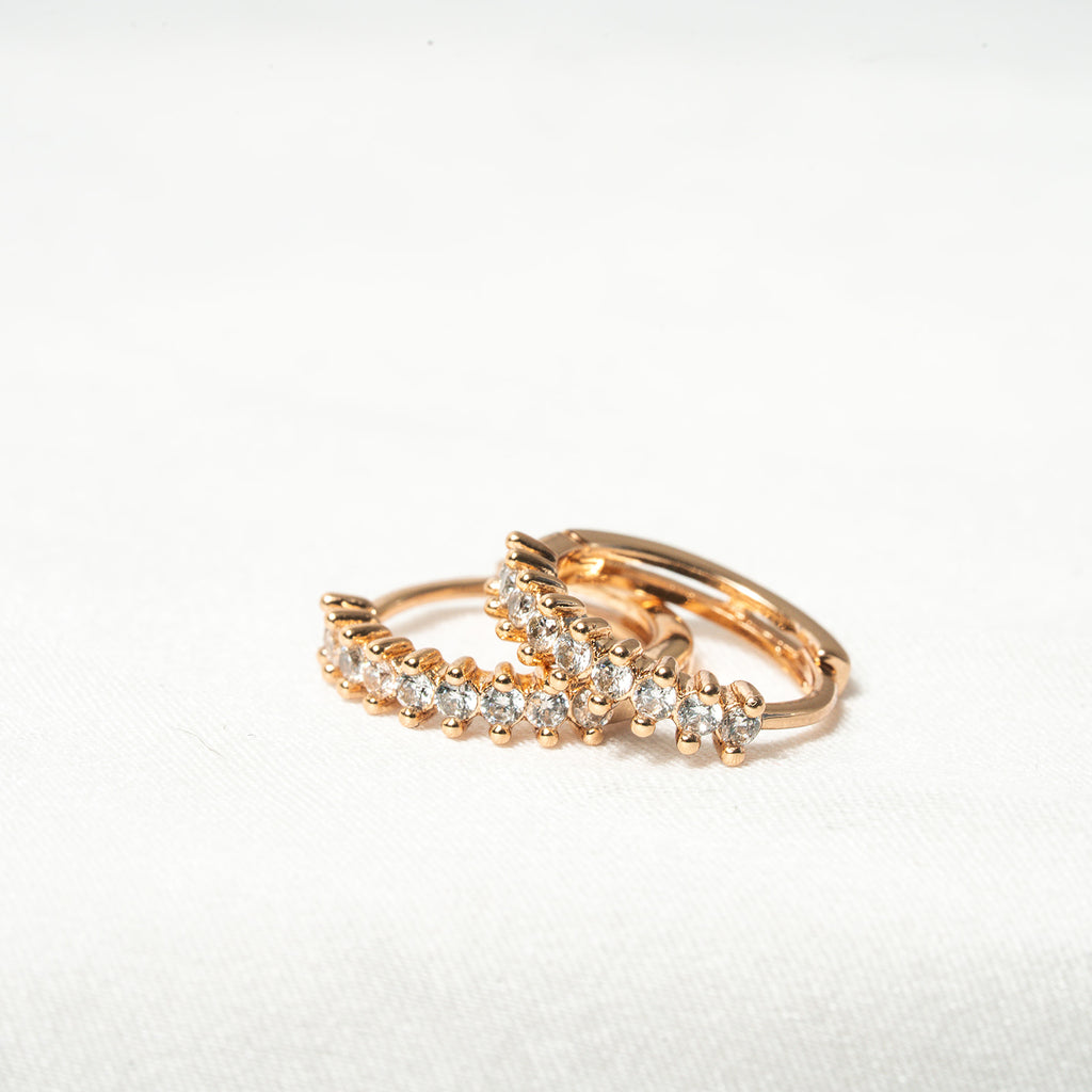 Rose gold ring with diamond accents on a white background Harma Aurora Glow Hoop Earrings