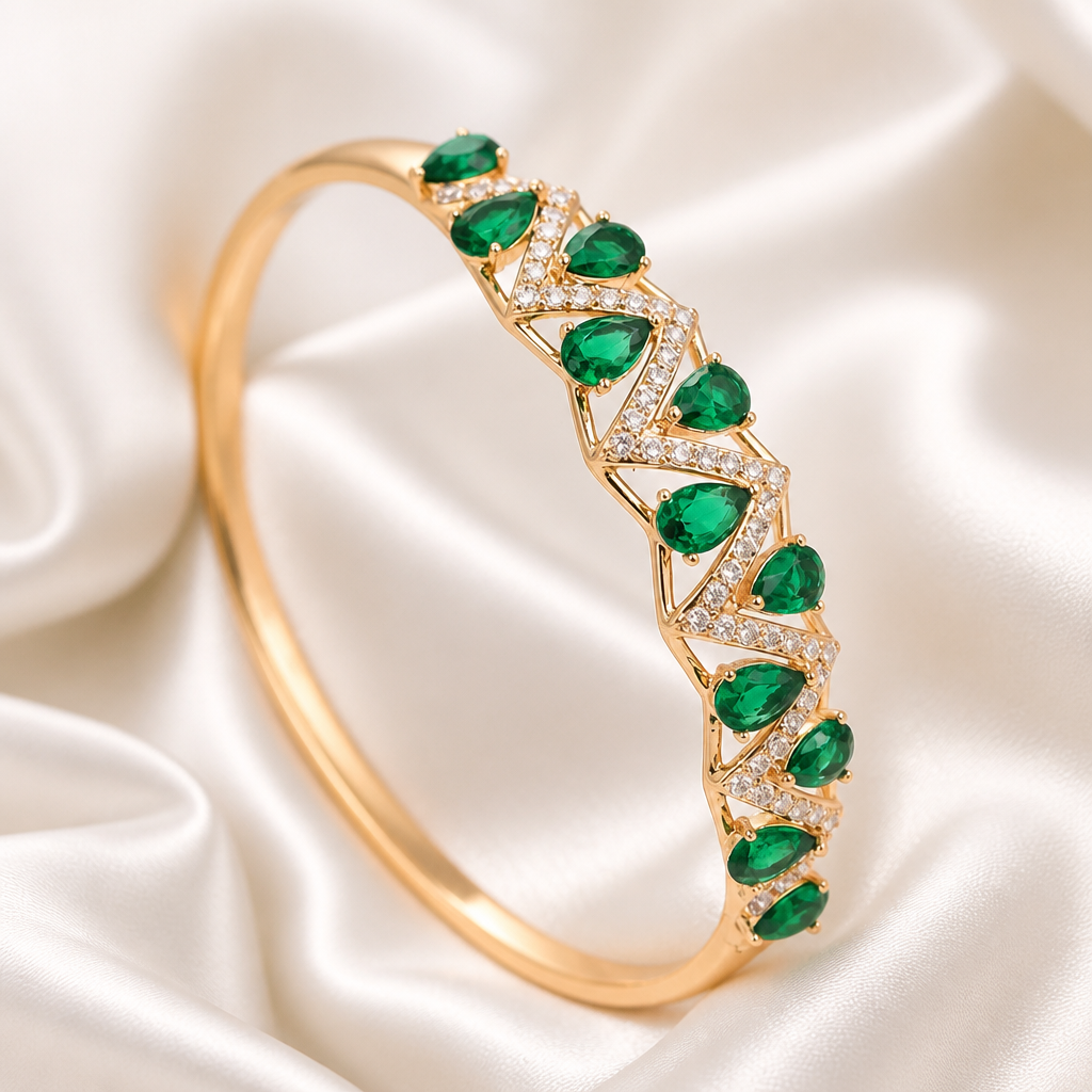 Gold bracelet with green gemstones on a satin background