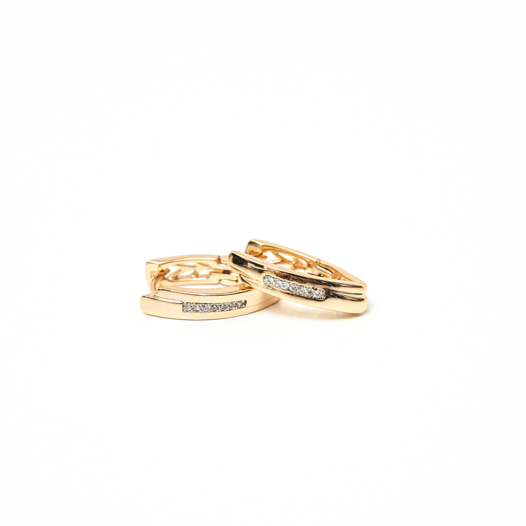Two gold rings with diamond accents on a white background. Harma Gold Plated Resilient Spark Gold Earrings