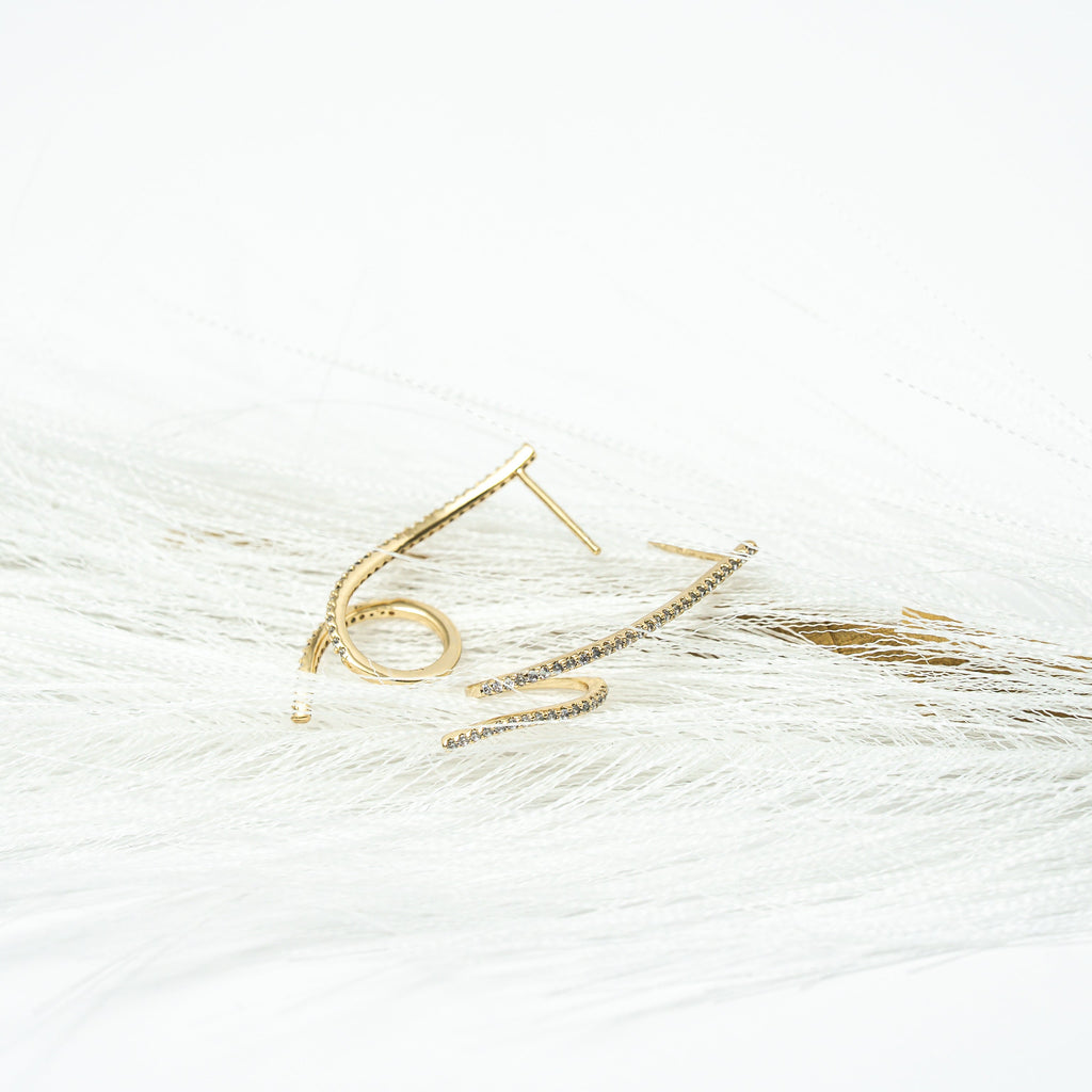 Gold ring with a small stone on a white background. Harma Gold plated Rise in Flow Sparkle Earrings