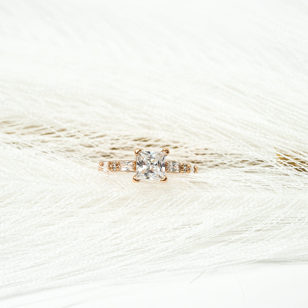 Gold ring with a Zirconia stone princess cut on a white background