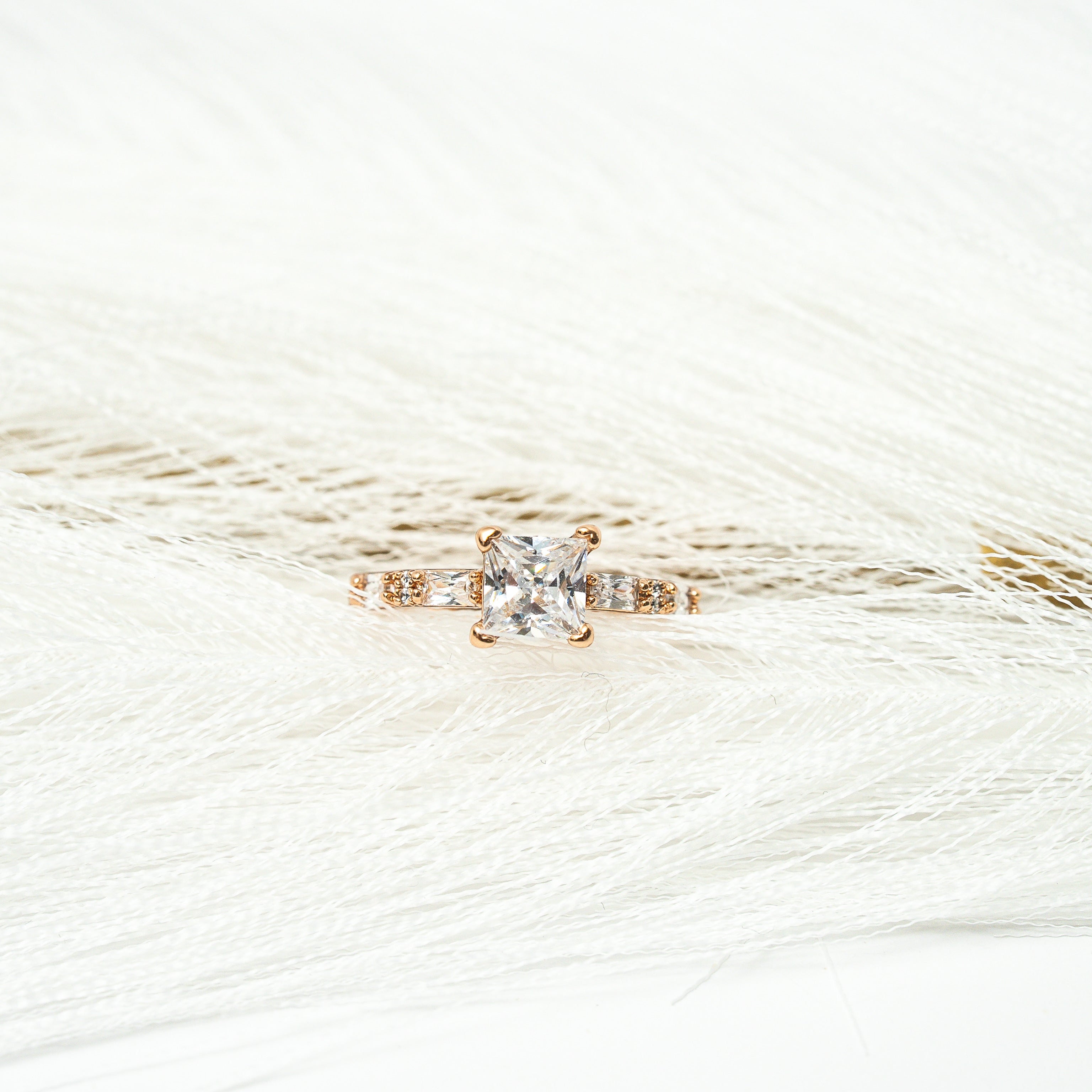 Gold ring with a Zirconia stone princess cut on a white background