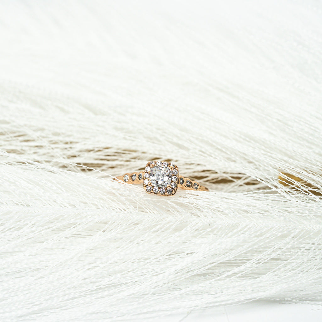 Rose gold ring with a diamond on a white feather