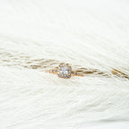 Rose gold ring with a diamond on a white feather