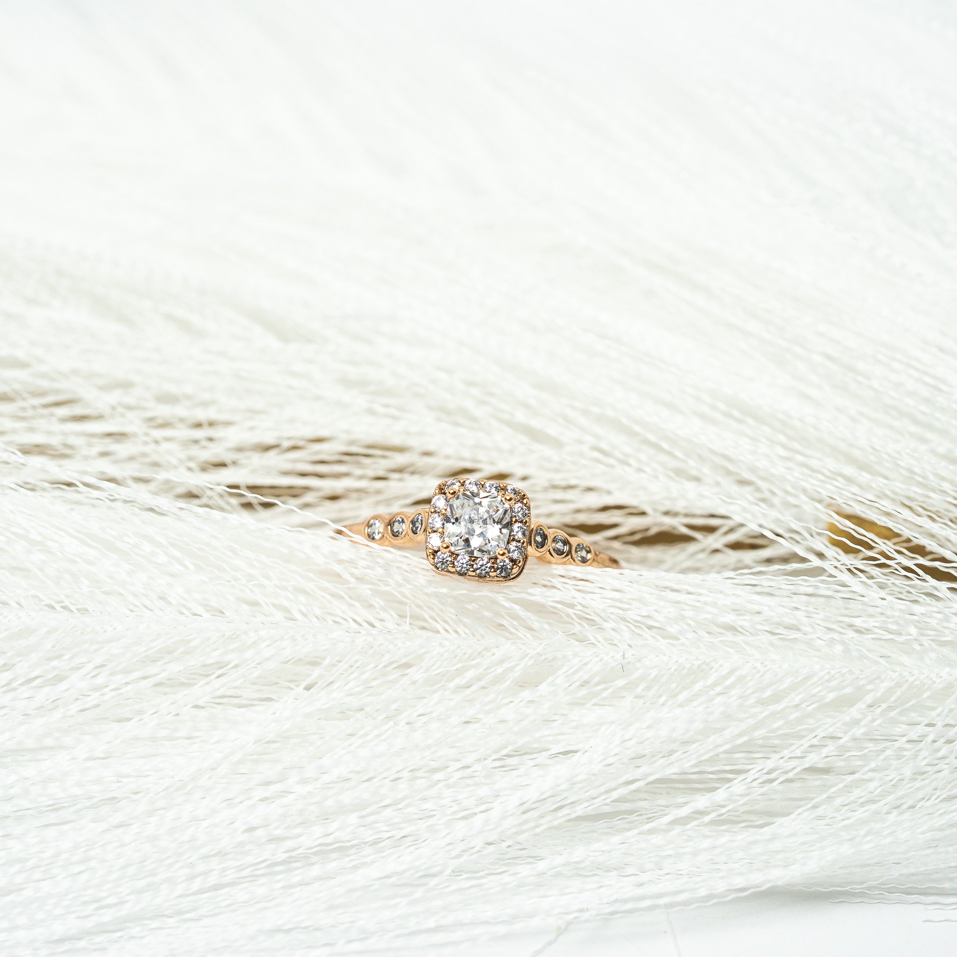 Rose gold ring with a diamond on a white feather