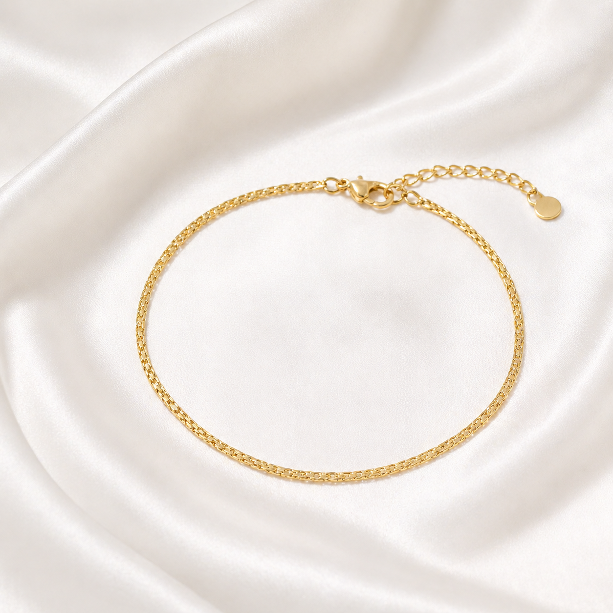 Gold Anklet on a white satin background