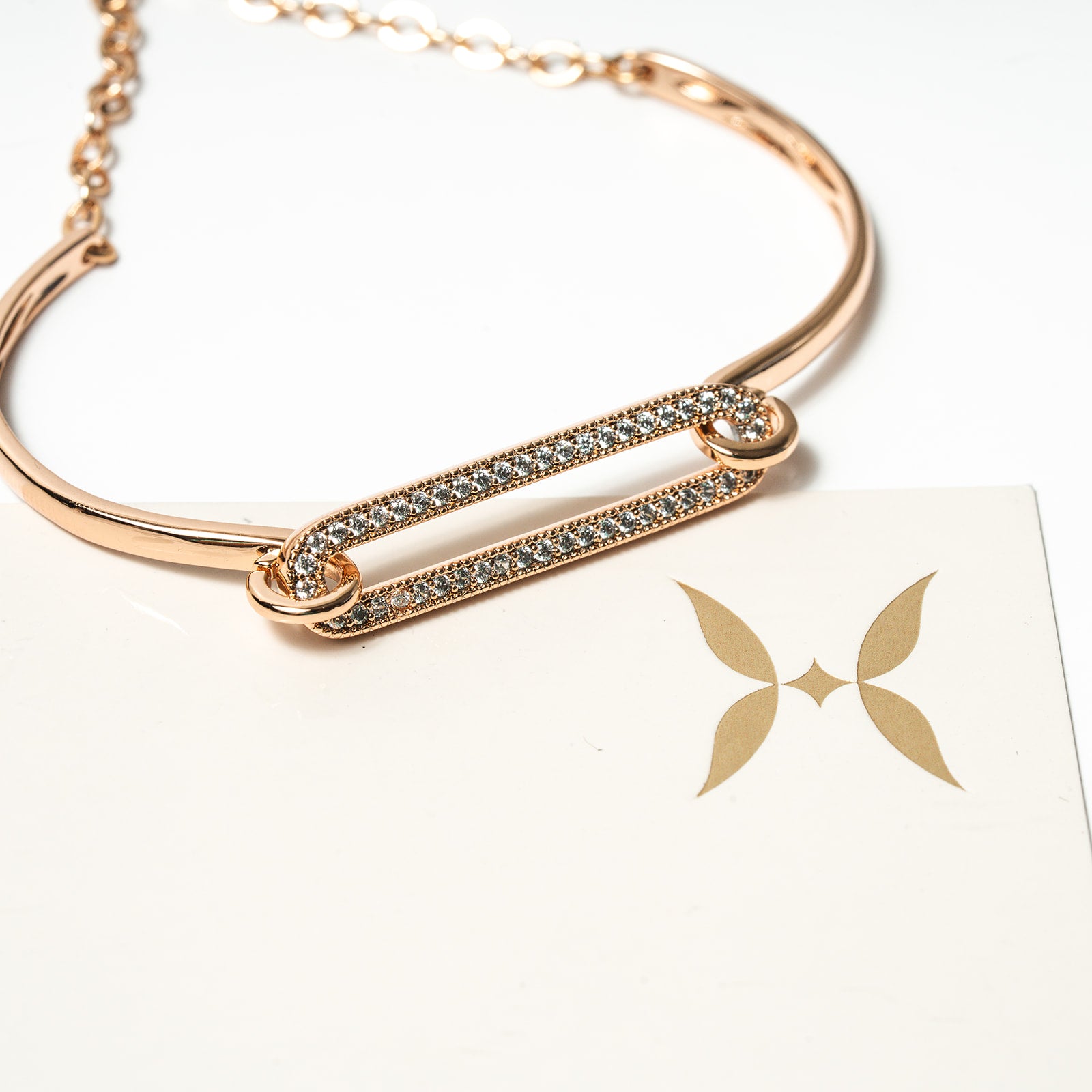 Rose gold bracelet with diamond accents on a white background. Harma Jewelry Cubic Zirconia Incrusted Sumptuous Paper Clip Bangle Chain