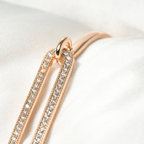 Rose gold hoop earrings with clear gemstones on a white background. Harma Jewelry Cubic Zirconia Incrusted Sumptuous Paper Clip Bangle Chain
