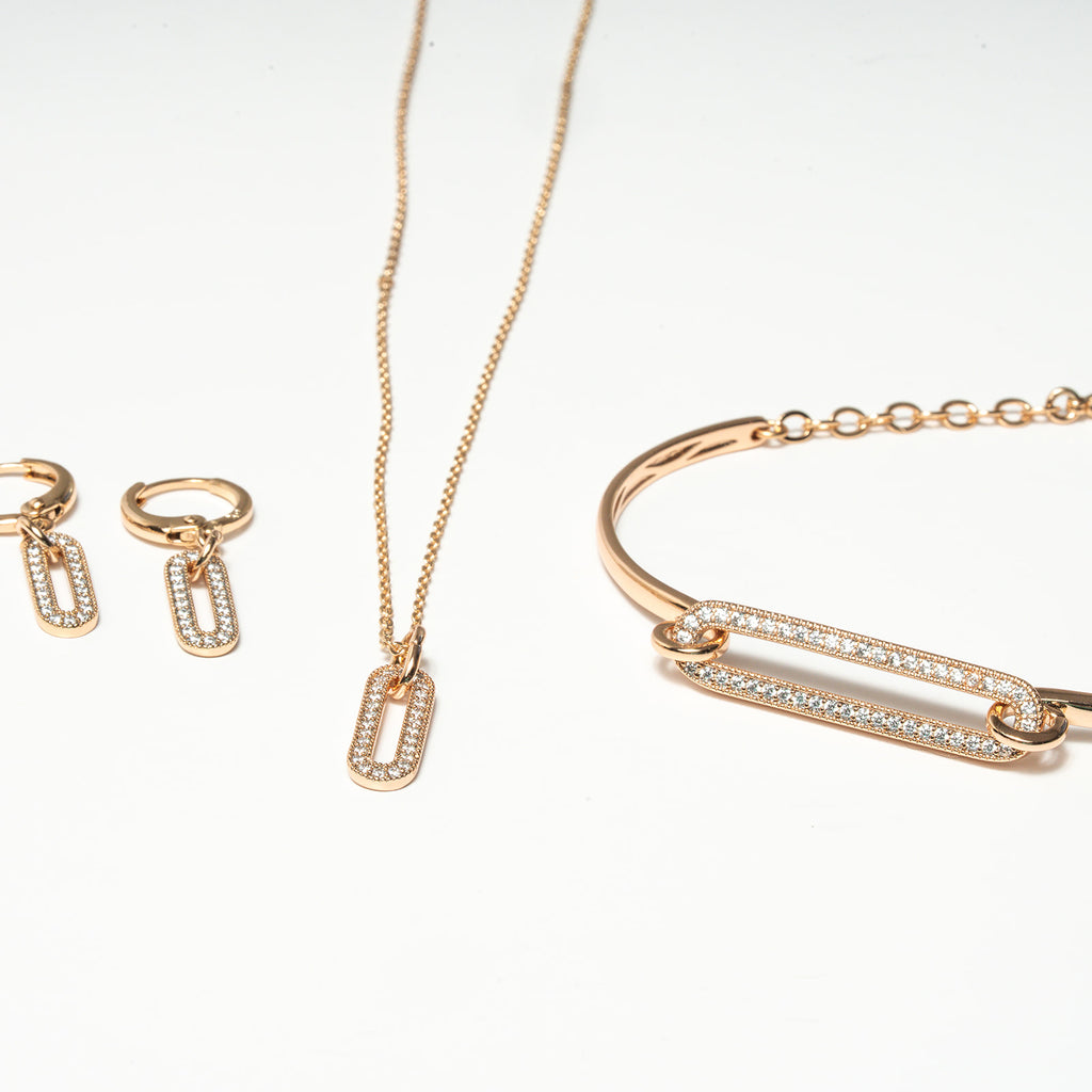Rose gold jewelry set including necklace, bracelet, and earrings on a white background. Harma Jewelry Cubic Zirconia Incrusted Sumptuous Paper Clip Bangle Chain Necklace Earrings Set