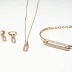 Rose gold jewelry set including necklace, bracelet, and earrings on a white background. Harma Jewelry Cubic Zirconia Incrusted Sumptuous Paper Clip Bangle Chain Necklace Earrings Set