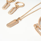 Rose gold necklace with diamond-encrusted pendants on a white background. Harma Jewelry Cubic Zirconia Incrusted Sumptuous Paper Clip Bangle Chain Necklace Earrings Set