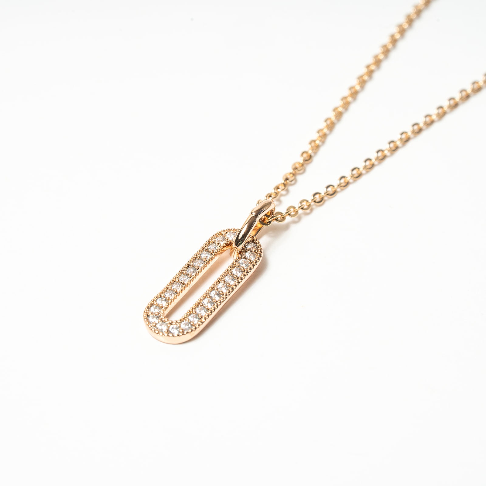Gold necklace with a rectangular pendant on a white background. Harma Jewelry Cubic Zirconia Incrusted Sumptuous Paper Clip Pendant Necklace Set