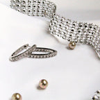 Silver bracelet, ring, and earrings on a white background Harma Jewelry Cubic Zirconia Inside out Huggie Hoop Earrings 