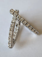 Pair of diamond-studded earrings on a light background Harma Jewelry Cubic Zirconia Inside out Huggie Hoop Earrings 