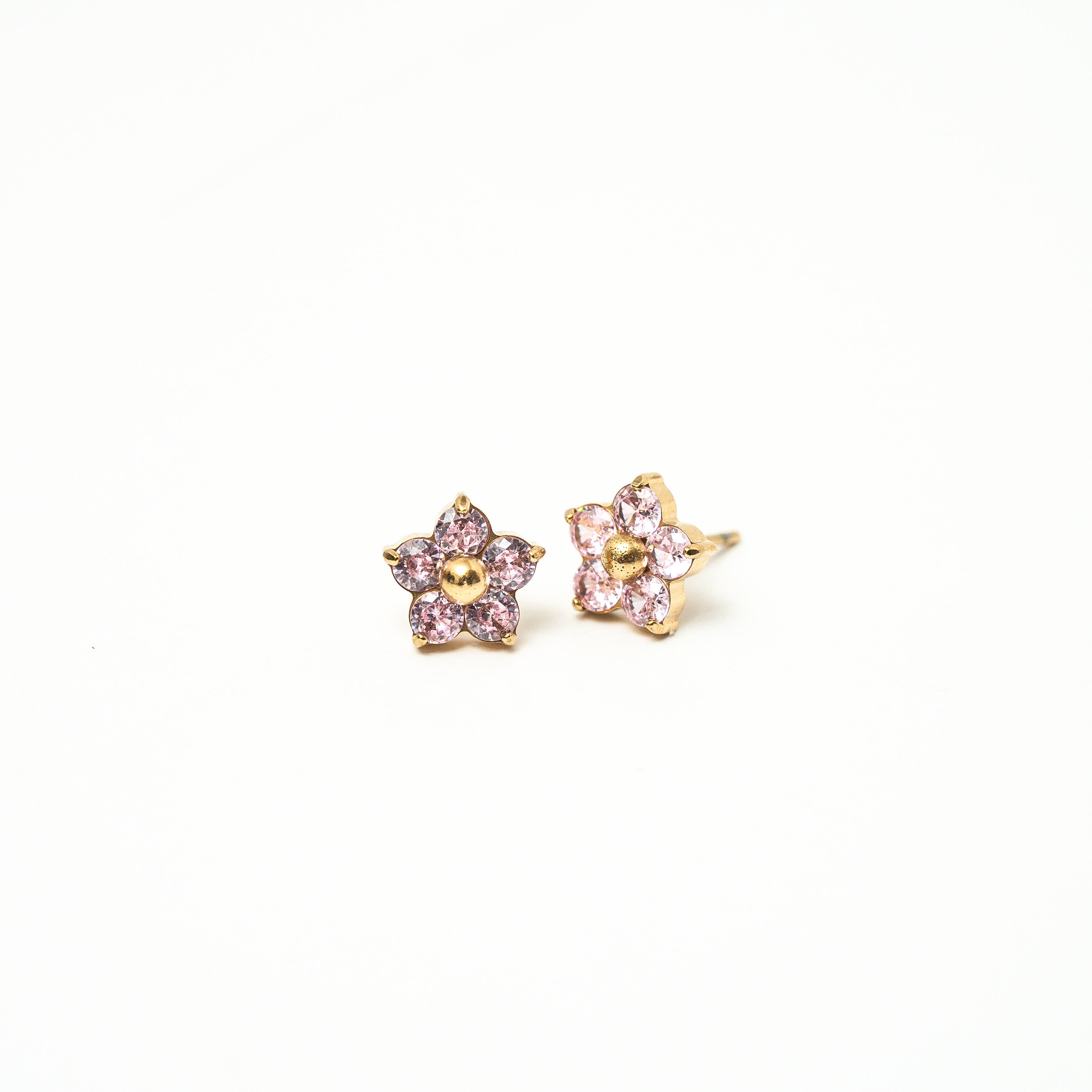 Pair of star-shaped earrings with pink gemstones on a white background. Harma Jewelry Gold Plated Little Bloom PINK Zirconia Earrings