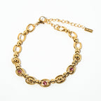 Gold bracelet with pink gemstones on a white background