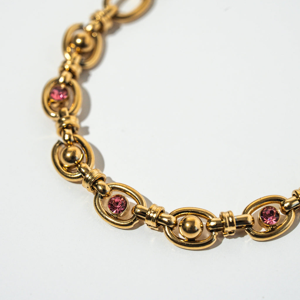 Gold bracelet with pink gemstones on a white background. Harma Jewelry Gold plated Unbreakable Link Pink Zirconia Bracelet