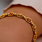 Gold bracelet with gemstones on a wrist against a neutral background. Harma Jewelry Gold plated Unbreakable Link Pink Zirconia Bracelet