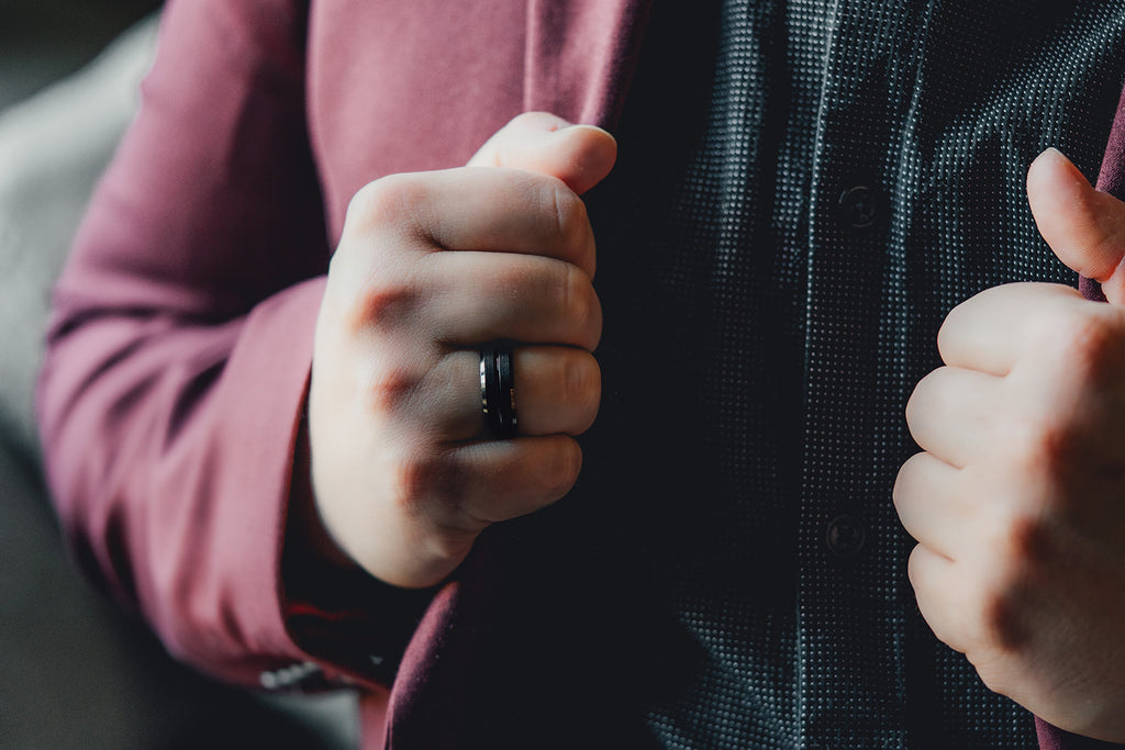 Close-up of a person wearing a ring on their finger with a blurred background Harma Jewelry Men Tungsten Carbide Band Ring Black Barrel Simple 