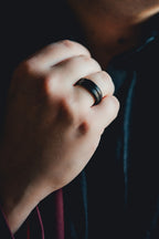Close-up of a hand wearing a black ring with a blurred background Harma Jewelry Men Tungsten Carbide Band Ring Black Barrel Simple 