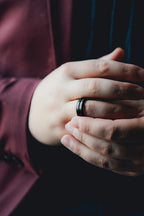 Close-up of a hand wearing a black ring with a blurred background Harma Jewelry Men Tungsten Carbide Band Ring Black Barrel Simple 