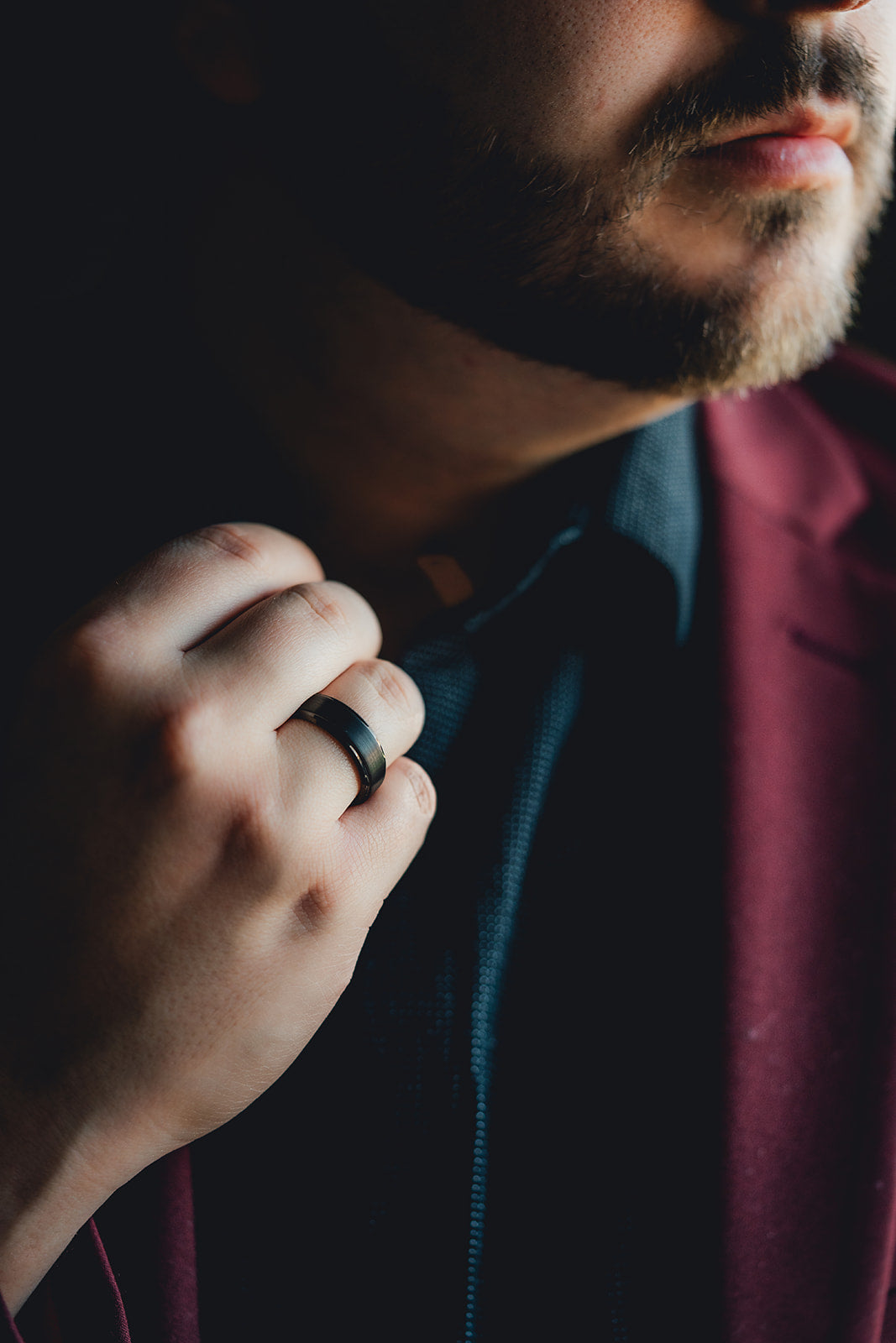 Man adjusting his collar with a close-up of his hand and ring. Harma Jewelry Men Tungsten Carbide Band Ring Black Simple 