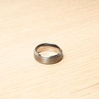 Silver ring on a wooden surface. Harma Jewelry Men Tungsten Carbide Band Ring Silver Simple 