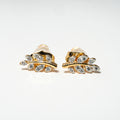 Gold leaf-shaped earrings with clear gemstones on a white background. Harma Jewelry Olive Branch Of Hope Stud Earrings Full Cubic Zirconia Gold Plated