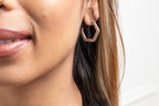 Close-up of a woman wearing a geometric hoop earring with a blurred background