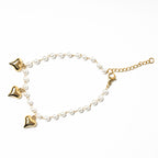 Gold anklets with heart-shaped charms and pearl beads on a white background. Harma Jewelry White Pearl Gold Heart Charm Bracelet