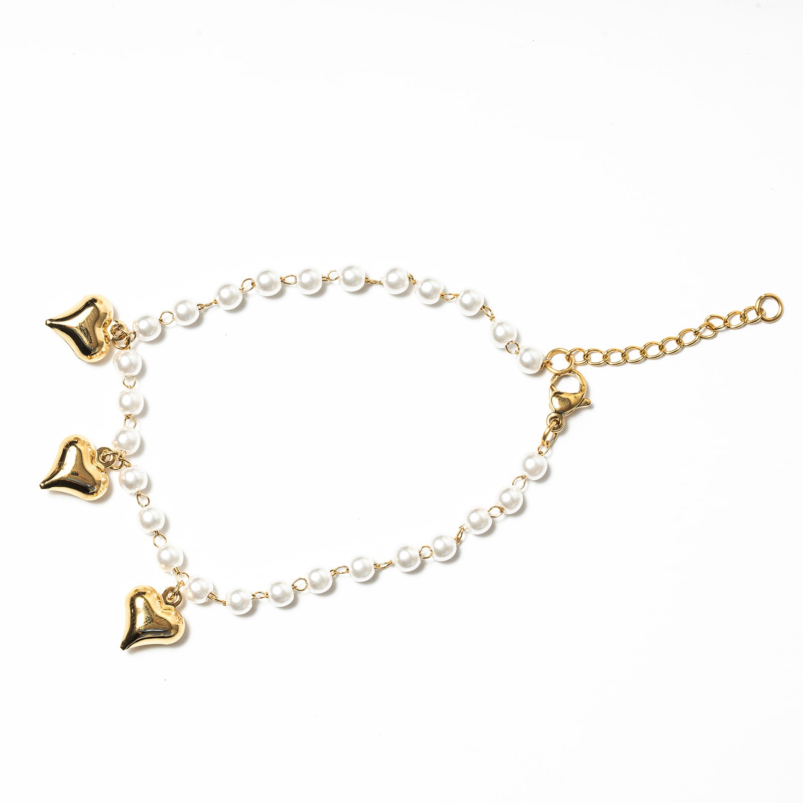 Gold anklets with heart-shaped charms and pearl beads on a white background. Harma Jewelry White Pearl Gold Heart Charm Bracelet