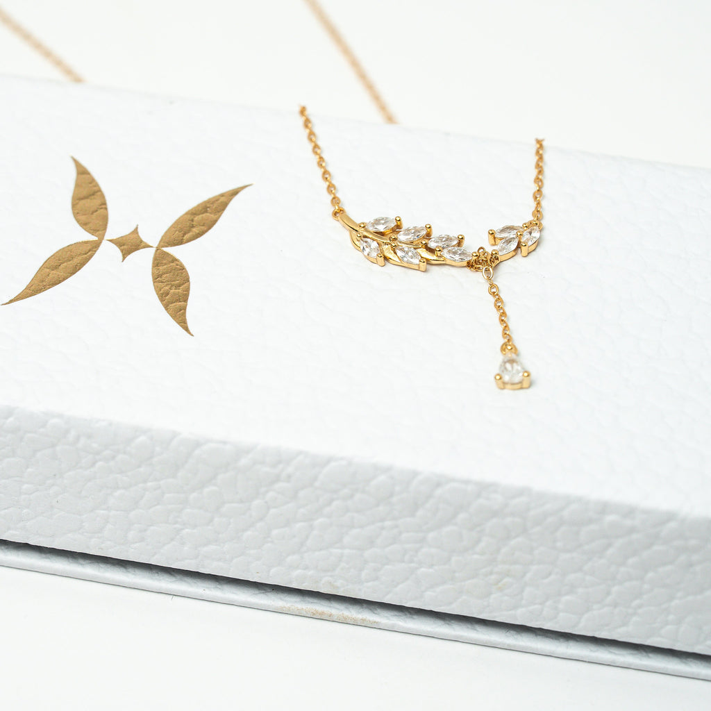 Gold necklace and earrings on a white card. Harma Jewelry gold plated I Am Flourishing Sterling Silver Zirconia Necklace
