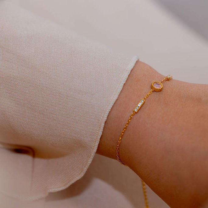 Gold bracelet on a wrist with a neutral background Harma Jewelry gold plated I Am Healing PINK Zirconia Bracelet