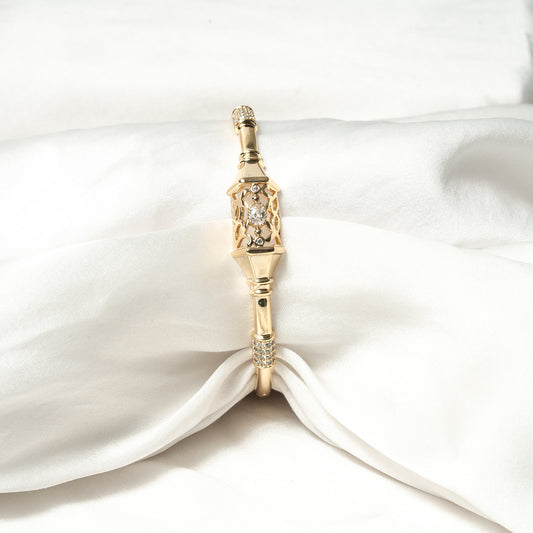 Gold pendant with gemstones on a white satin background Harma Luminous Noor Lantern Bracelet