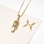 Gold necklace with a pendant on a white card with a brand logo. Harma Luminous Noor Lantern Necklace Set