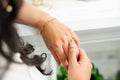 Close-up of a hand wearing a gold ring with a blurred background