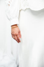 Close-up of a hand wearing a gold ring on a white background