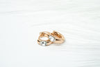 Rose gold ring with embedded gemstones on a white background